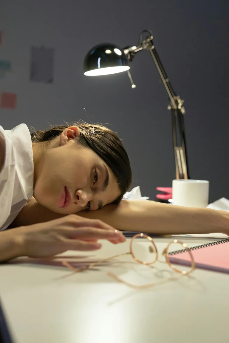 women resting her head on her arm on the desk